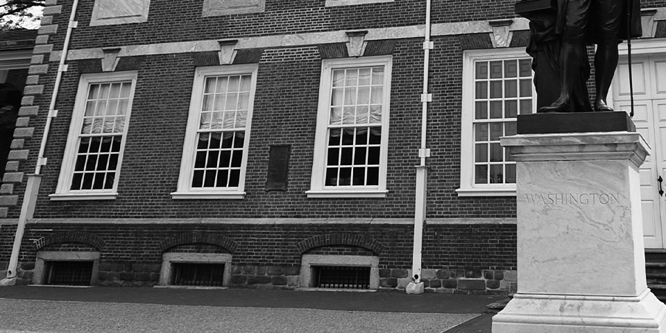 Black and white photo showing four closed windows.