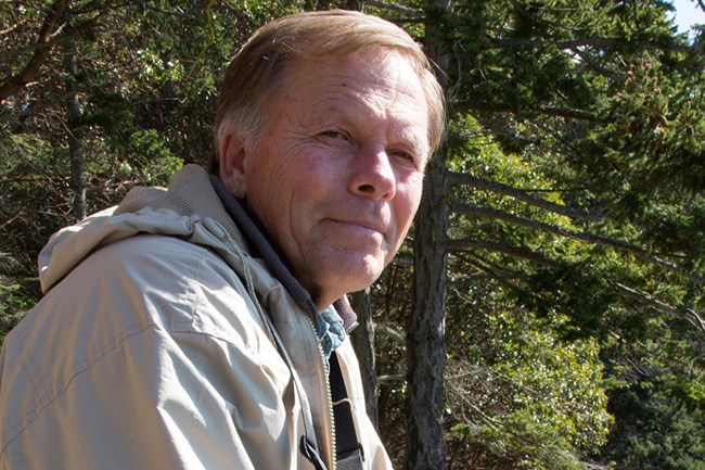 man with camera near trees