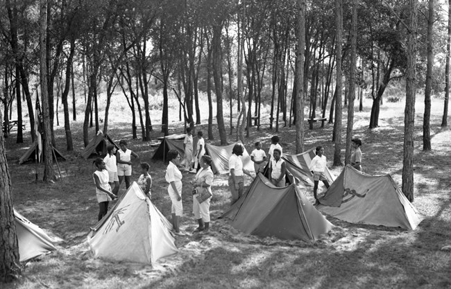 African American Girl Scouts setting up tents for a day trip at Paradise Park.