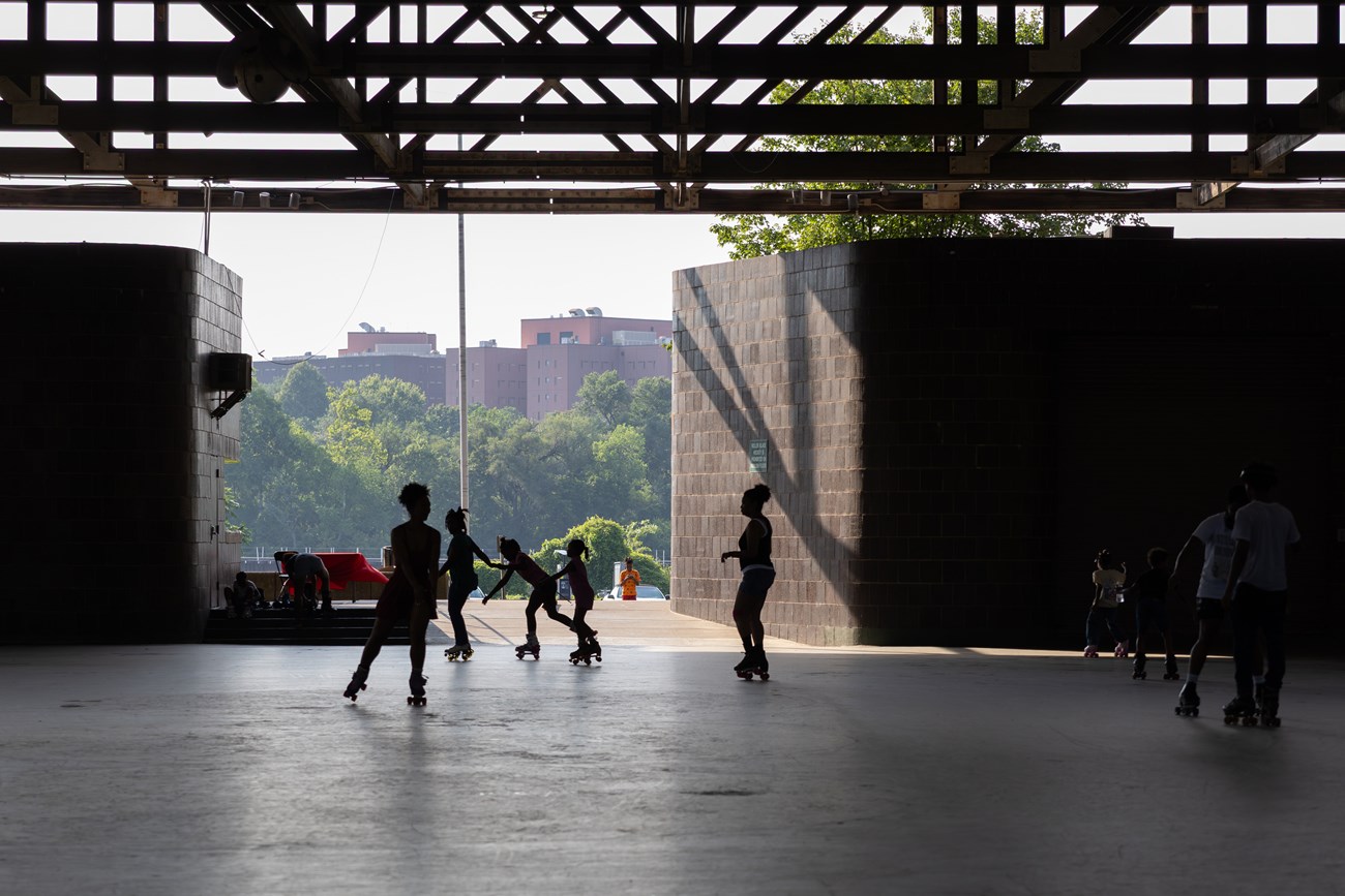Children hold hands as they roller skate