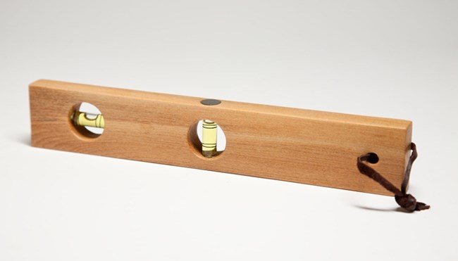 Wooden rectangle with two circles cut through it, both with tubes holding yellow liquid