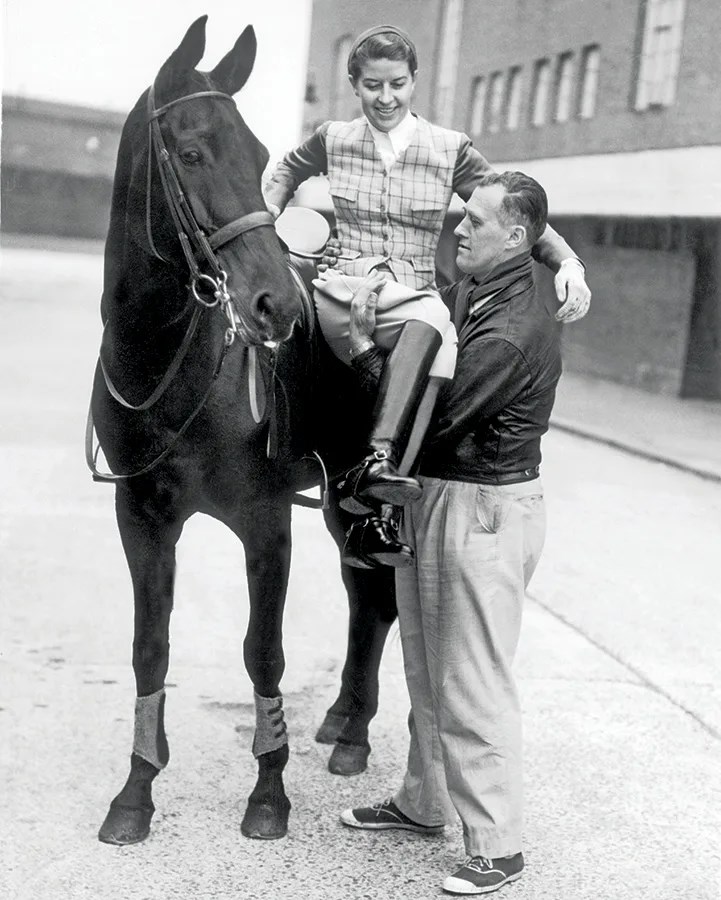 Henri Saint Cyr lifts Lis Hartel off of her horse.