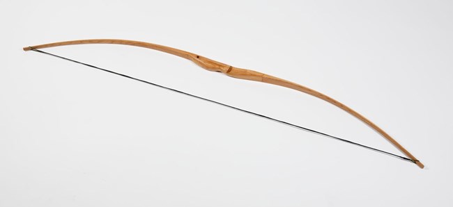 archery bow with wooden handle and string to pull back