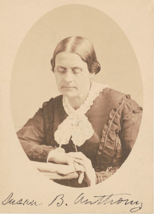 Portrait of an older woman wearing a 19th century dress and glasses