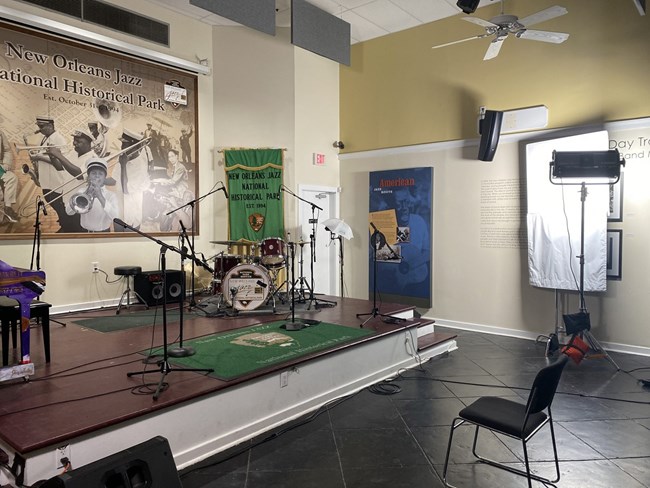 midsize stage with instruments like drums, plus lighting, sound and camera equipment