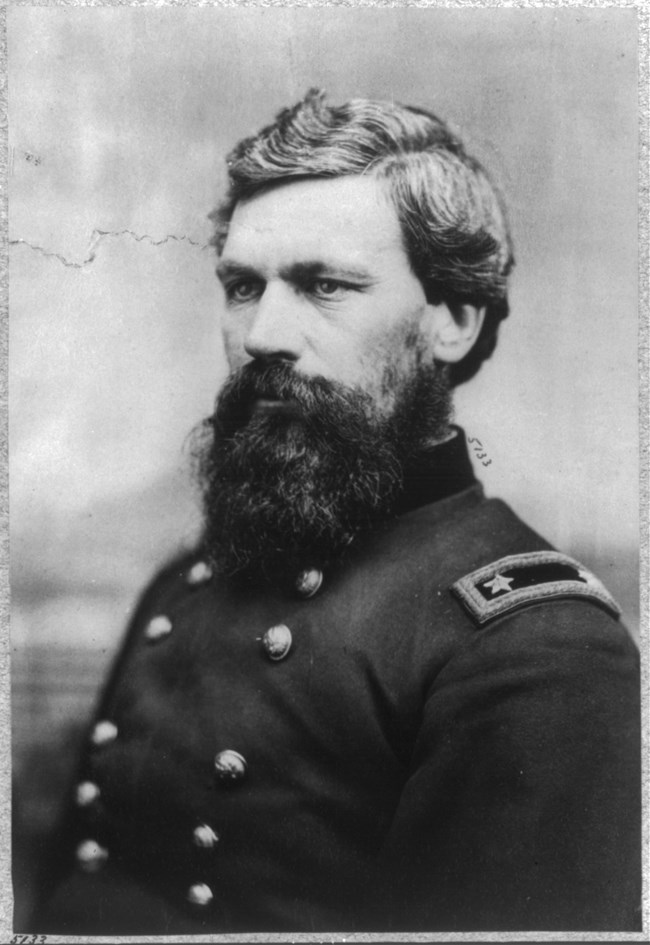 A man with salt and pepper hair and a large beard wearing a general's uniform.