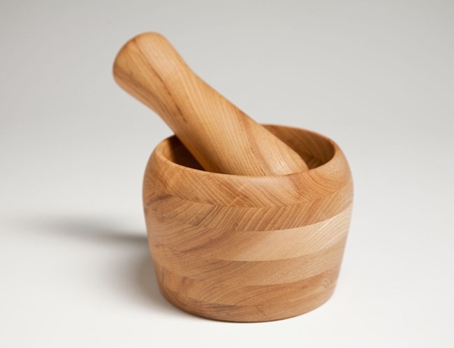 small wooden bowl with a small thick bat inside