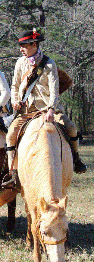 A man in 18th century clothing sits atop a yellow horse.