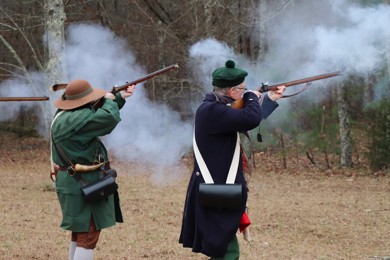 Reenactors firing muskets