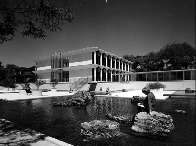 Black and white photo of students reading within and beside the reflecting pool.