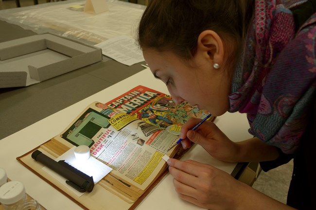 Cathie Magee testing the solubility of the printing inks on Captain America