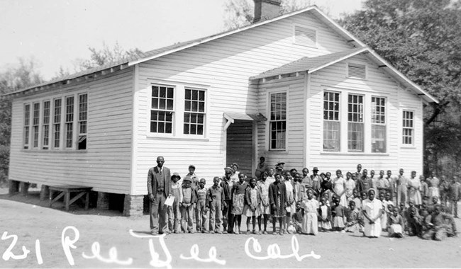 Students in front of old schoolhouse.