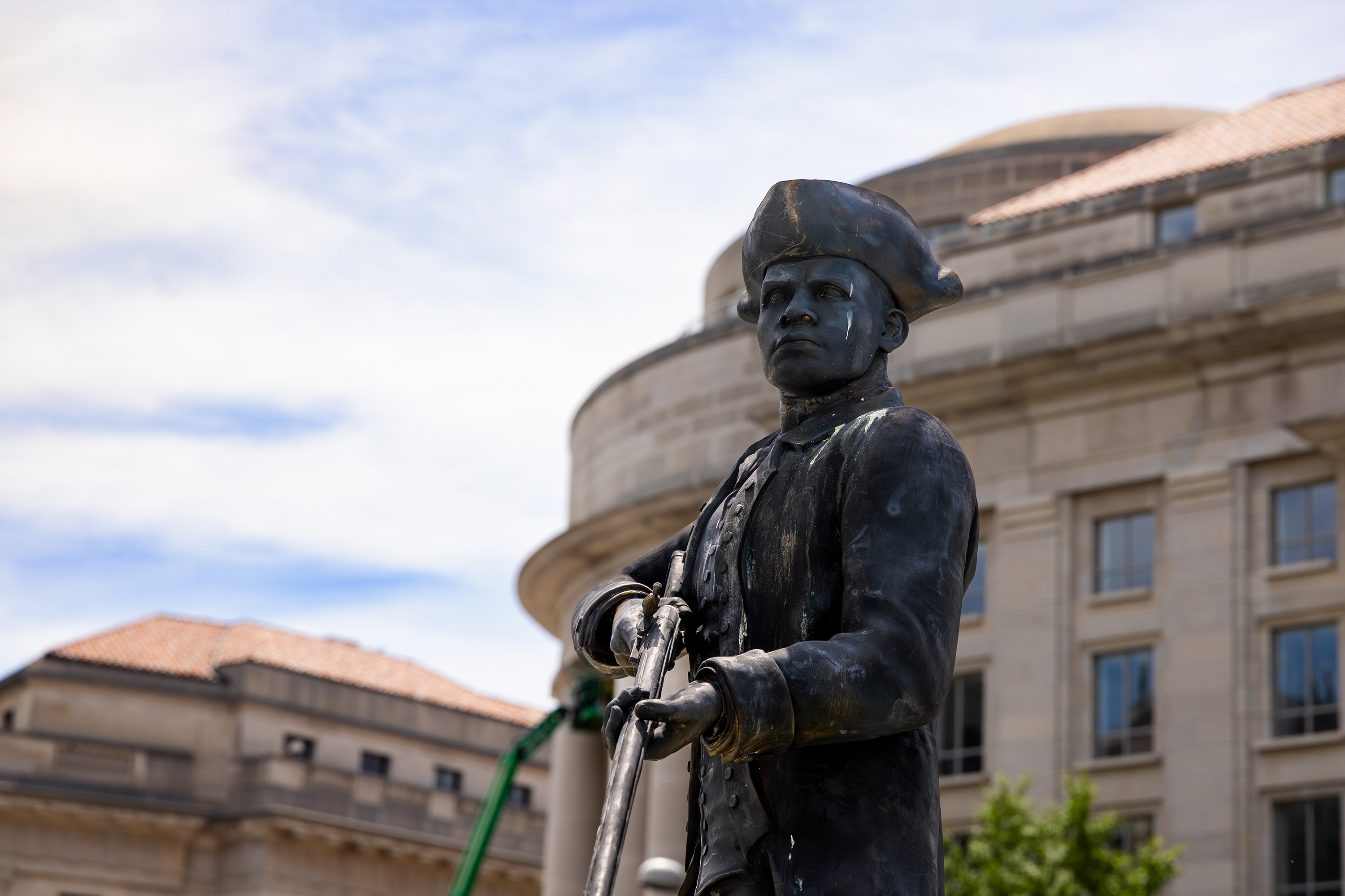 Dark bronze statue of man in tri-corner hat holding a rifle