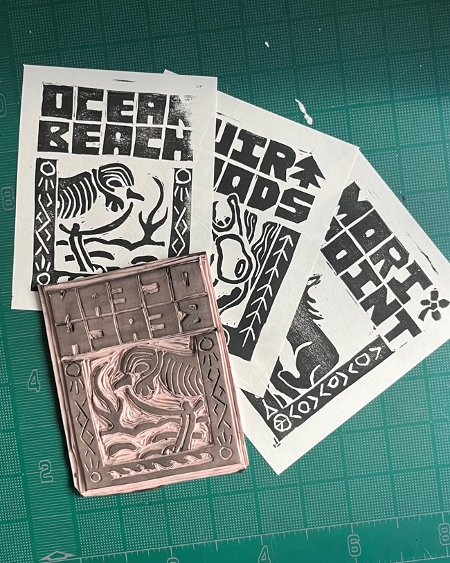 Three original paper and ink prints featured above, layed out of a green ruler mat, along with the hand-carved stamp used to create the Ocean Beach plover print.