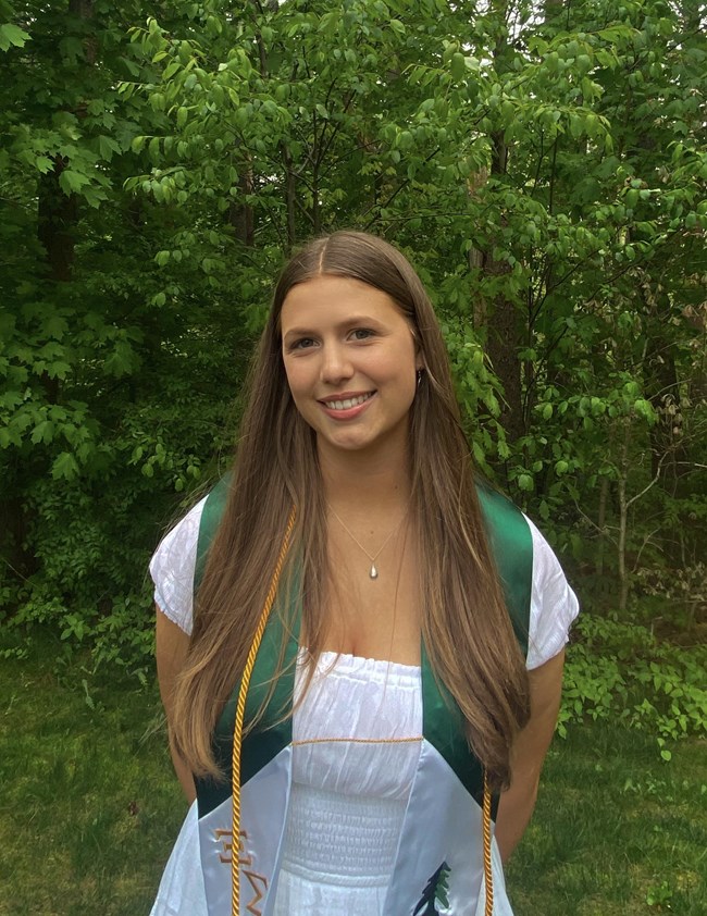 A woman wearing a white dress and green stole