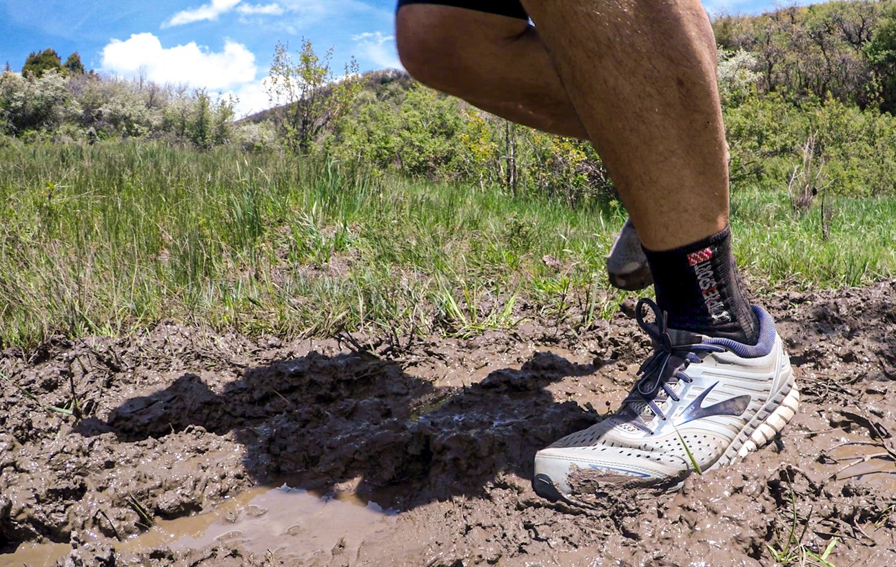close up image of someone's legs as they run through mud