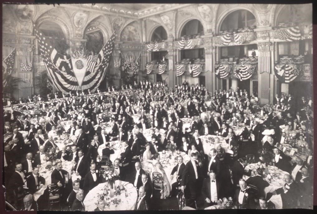 historic photo of a packed meeting room with multiple balconies overlooking a central floor