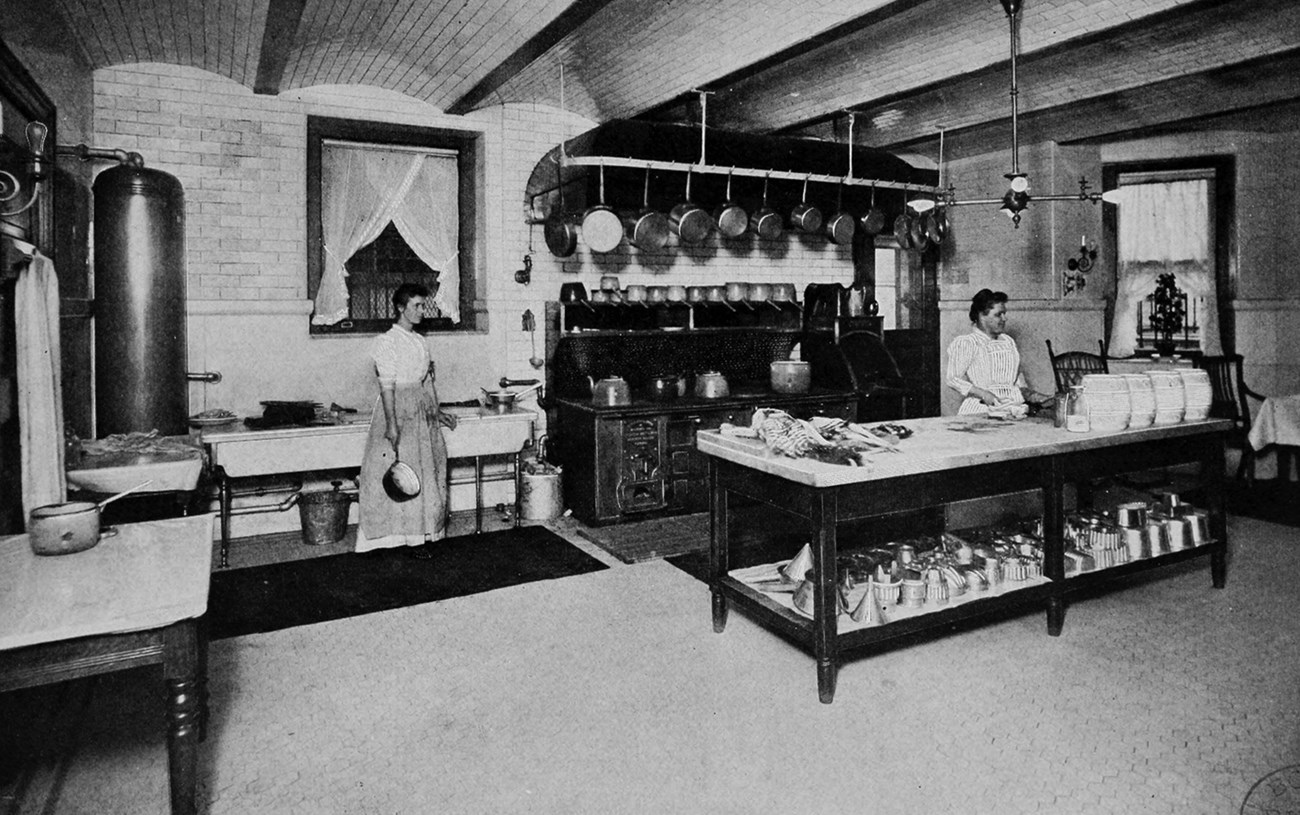 Two women in a large kitchen.