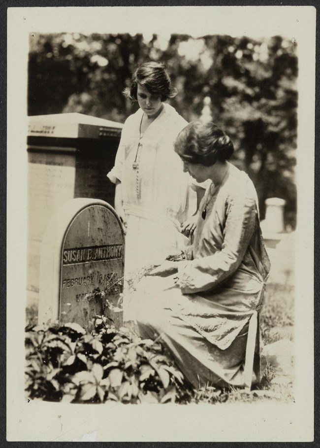 Two women at a gravesite.