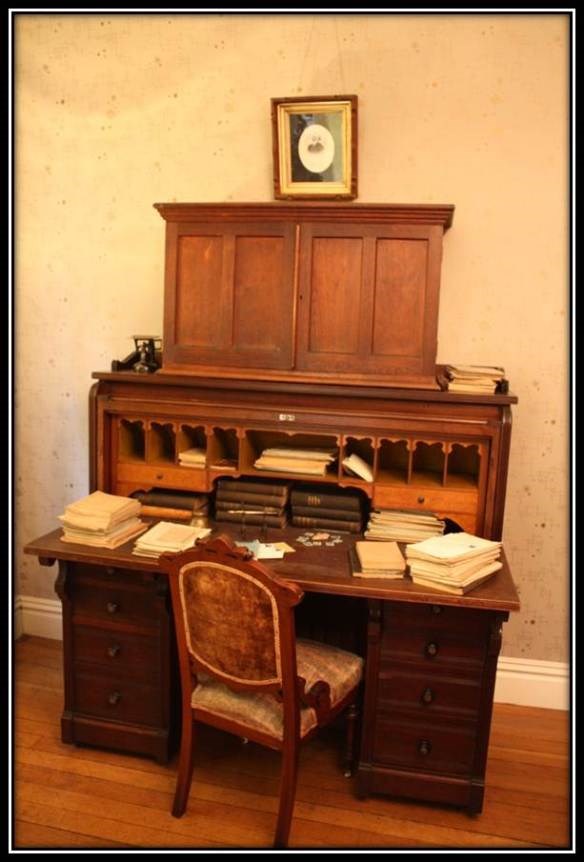 a writing desk with a small bookcase attached at the top with a chair that is pulled out for someone to sit