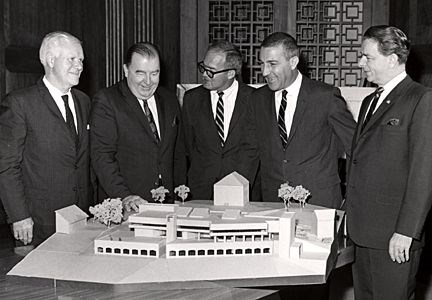 Five men stand behind a model of Interpretive Design Center