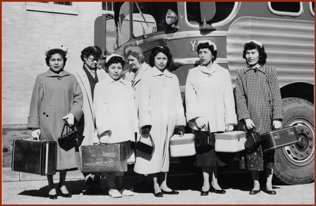 group of indigenous women with luggage in front bus c. 1956