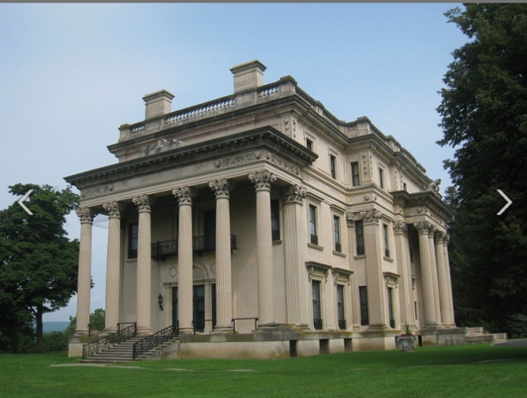 a large mansion that looks like it was made of concrete with pillars in the front
