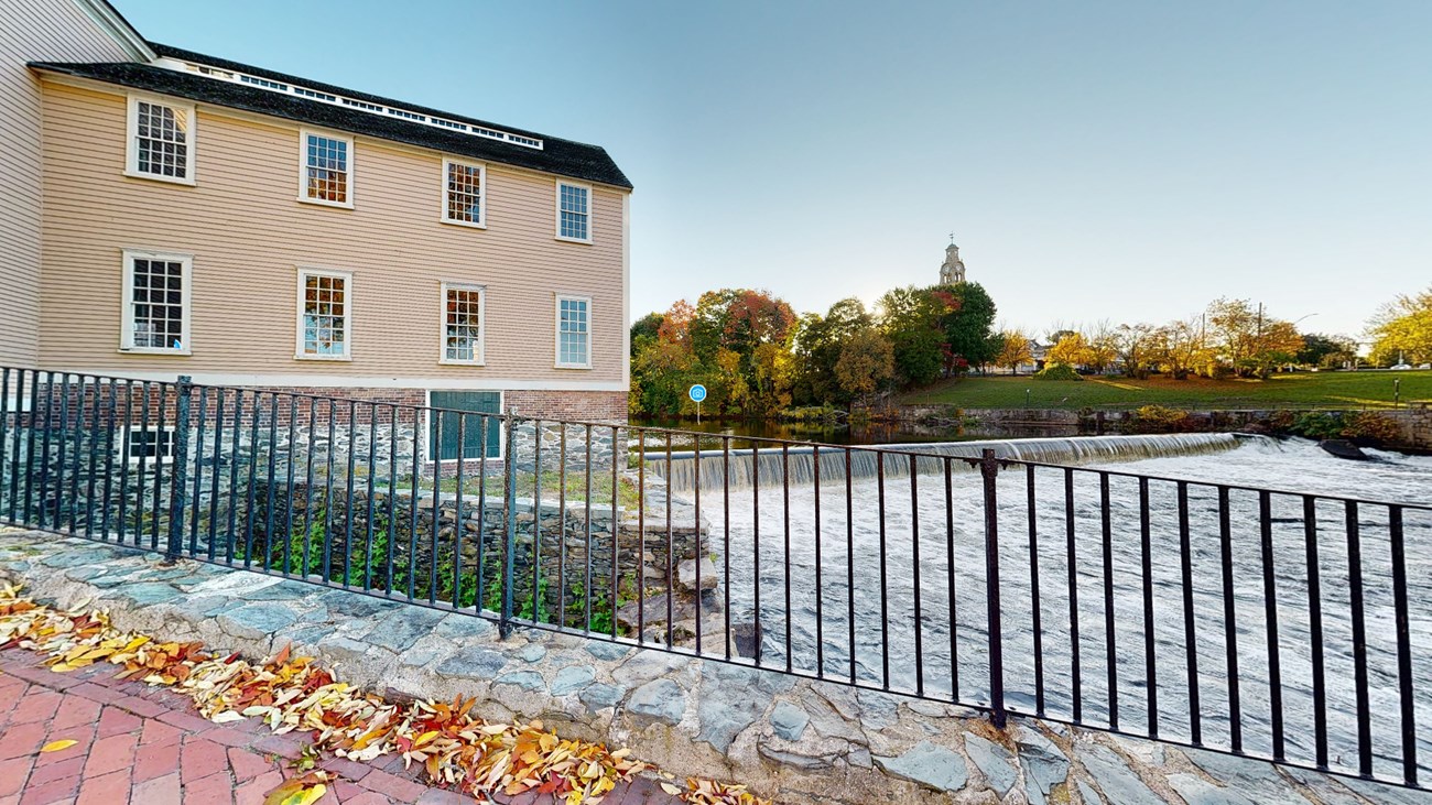 Virtual tour screenshot showing the river and falls that passing just beside the Slater Mill building.