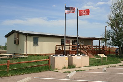 Front view of the White River Visitor Center with Oglala Lakota and USA flags flying