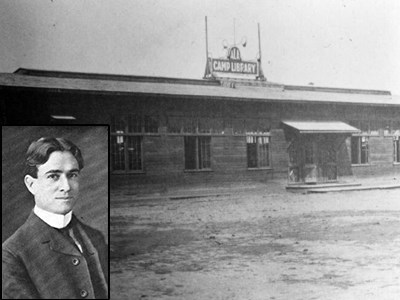 A one-story building with a "camp library" sign at the top and portrait of Burton E. Stevenson on lower left