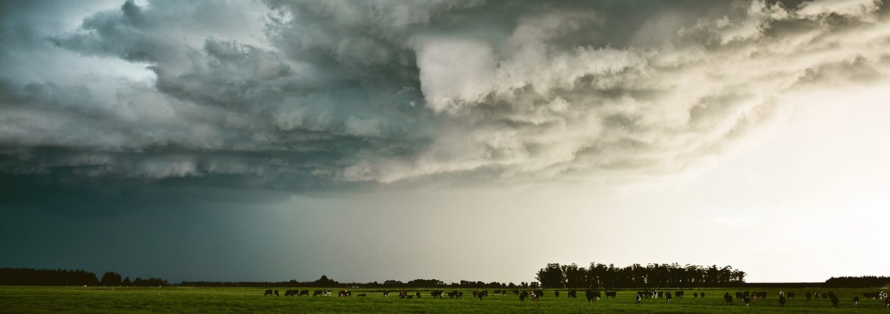 Dark storm clouds gathering over fields.
