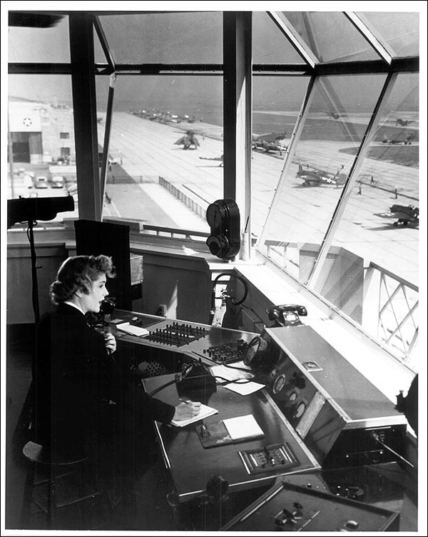 A woman air traffic controller operating radio equipment at the control tower, NAS- New York, 1943. (National Archives and Records Administration)