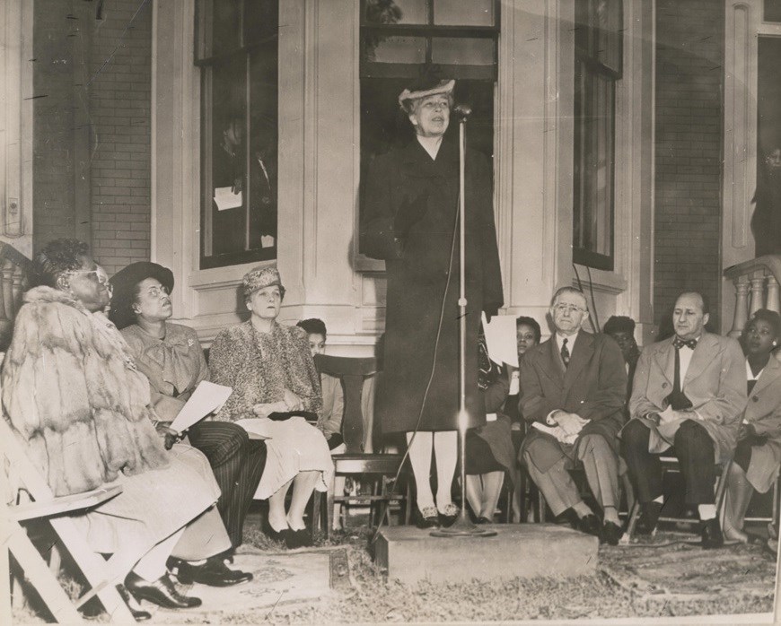 Woman speaking in front of group of seated women.