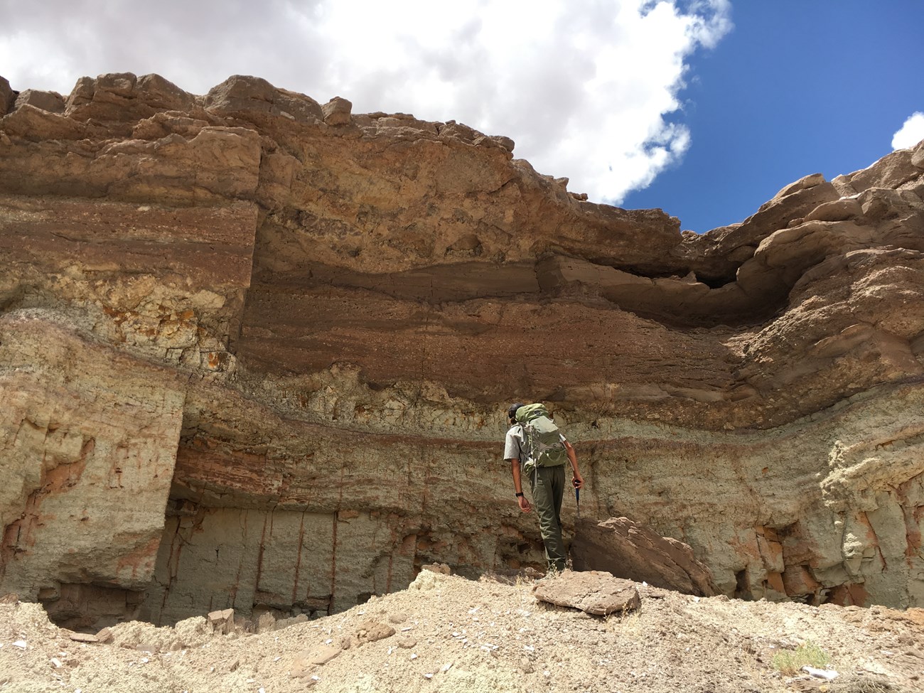 ranger approaching rocky cliff