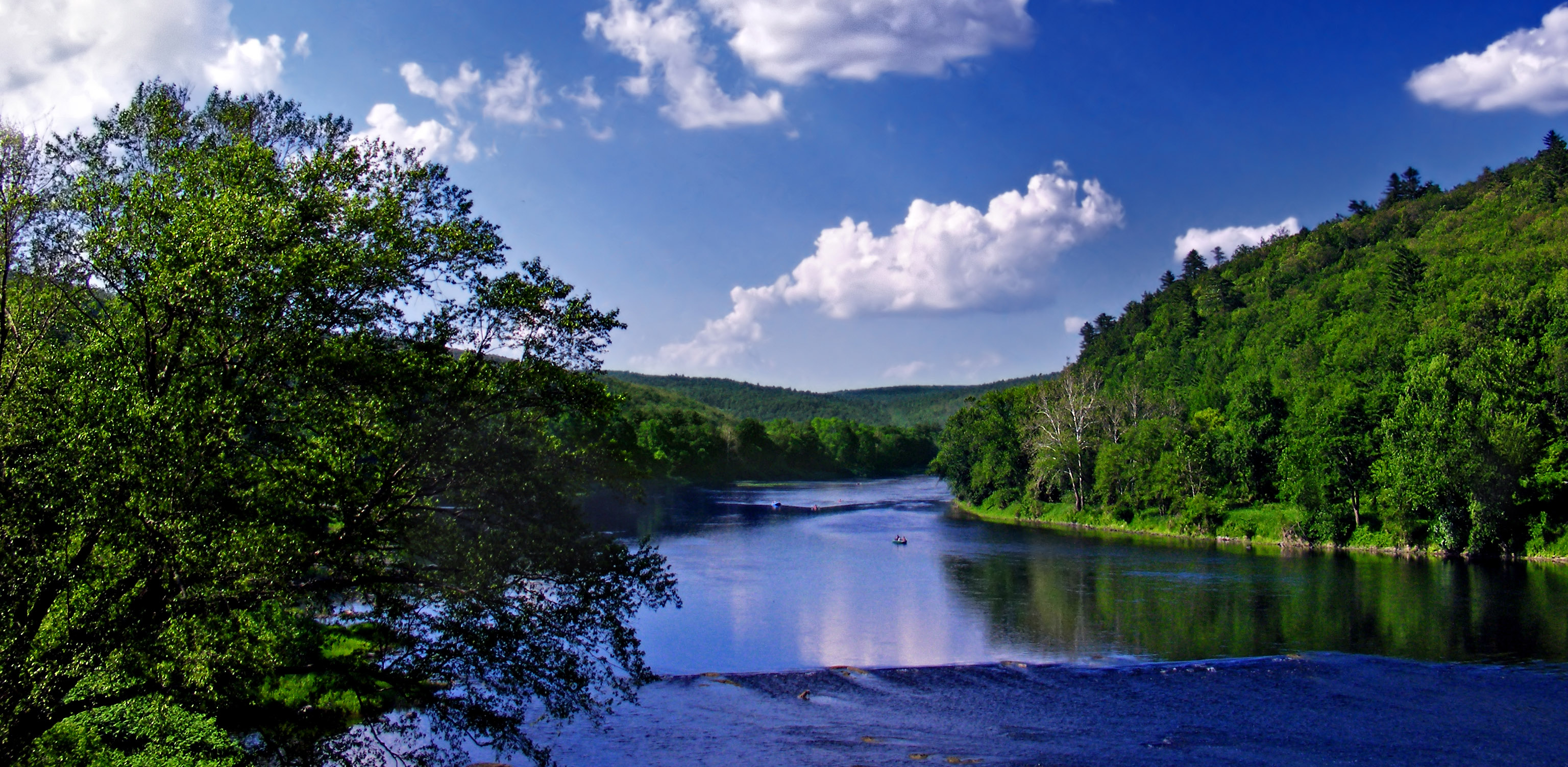 View of the Delaware River under a blue sky with puffy white clouds.