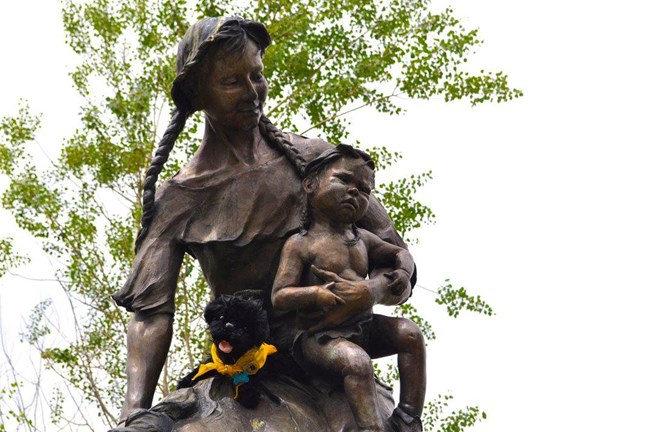 toy dog near statue of woman and child