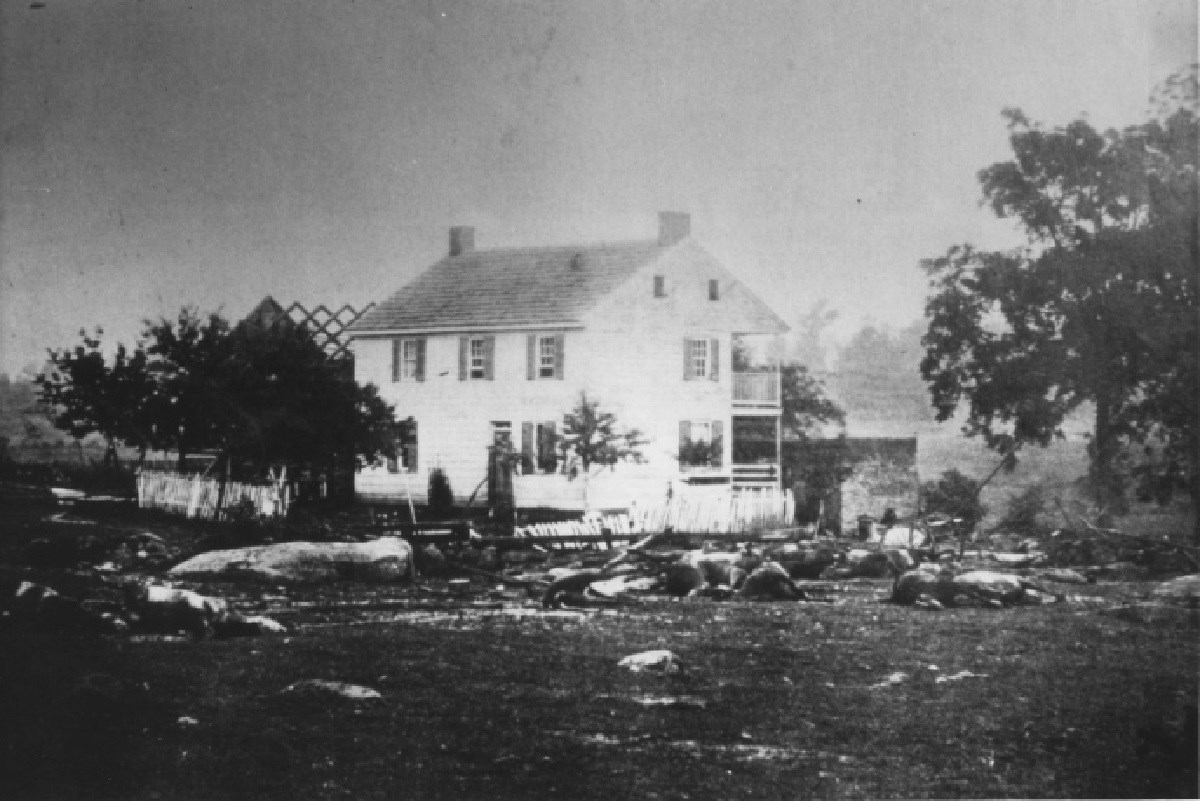 White two story house with debris scattered around.