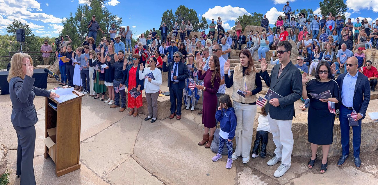 A gathering of 30 citizens raise their hands and take their oath of allegiance to become new US citizens.