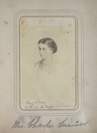 Black and white studio portrait of woman's head and shoulders. She looks slightly left.