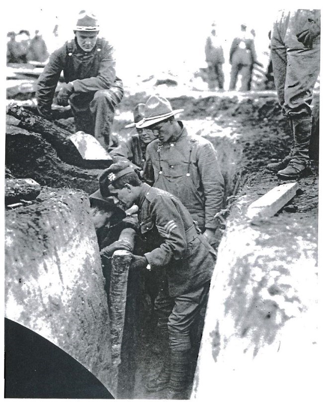 An instructor demonstrates proper trench reinforcement techniques for new recruits