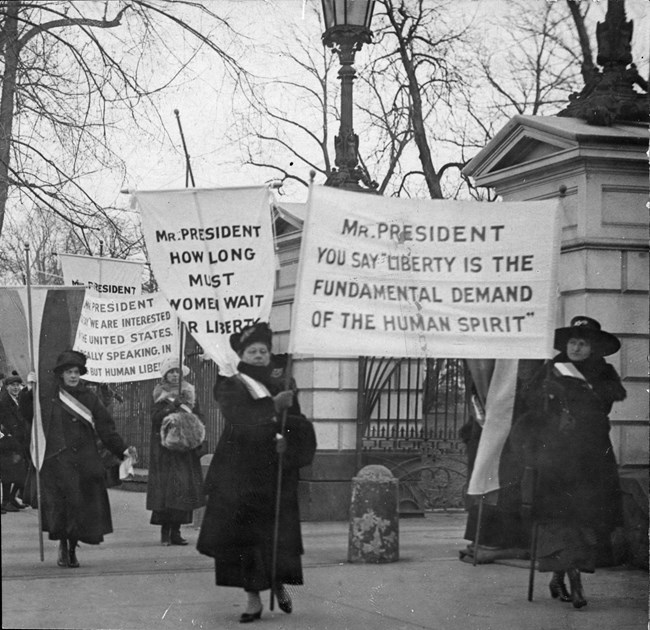 Women holding protest signs