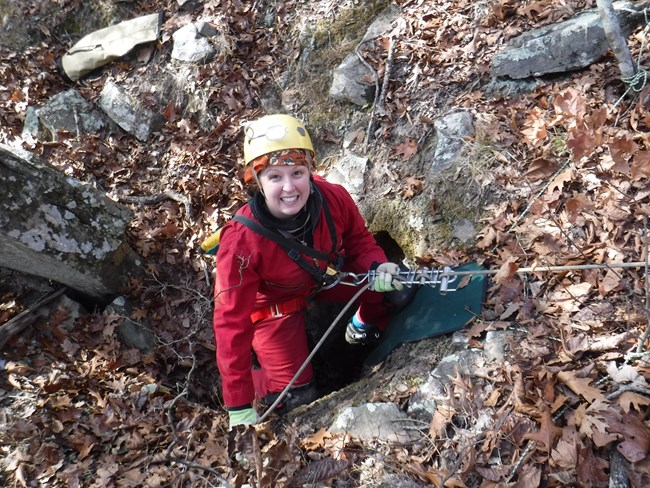 caver rappelling into a cave opening