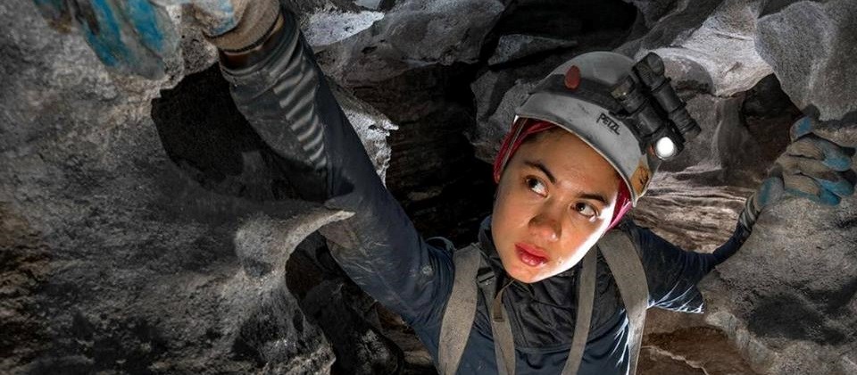 intern wearing helmet and gloves in a cave
