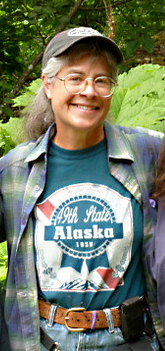 Woman with glasses and baseball cap smiling