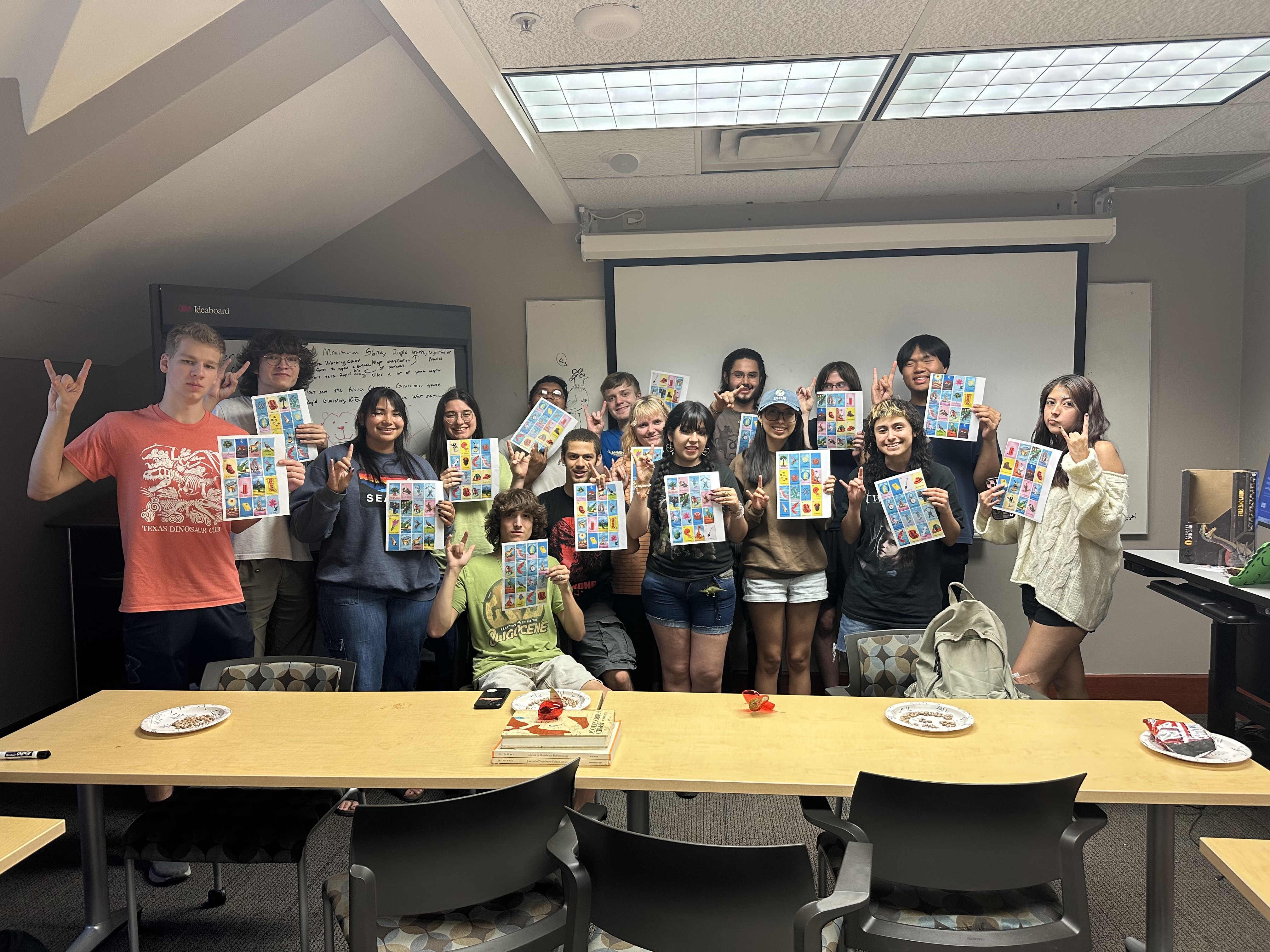 Group photo of Texas Dinosaur Club members holding up their Paleotería boards after a successful playthrough