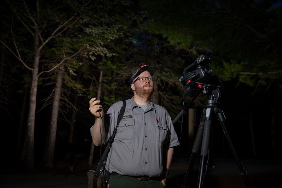 Biologist with technical equipment in night darkness
