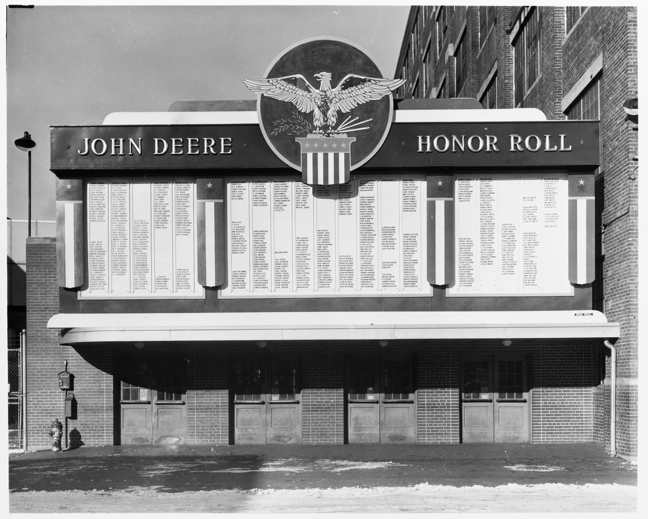 Black and White photo of building front with words John Deere Honor Roll and long list of names