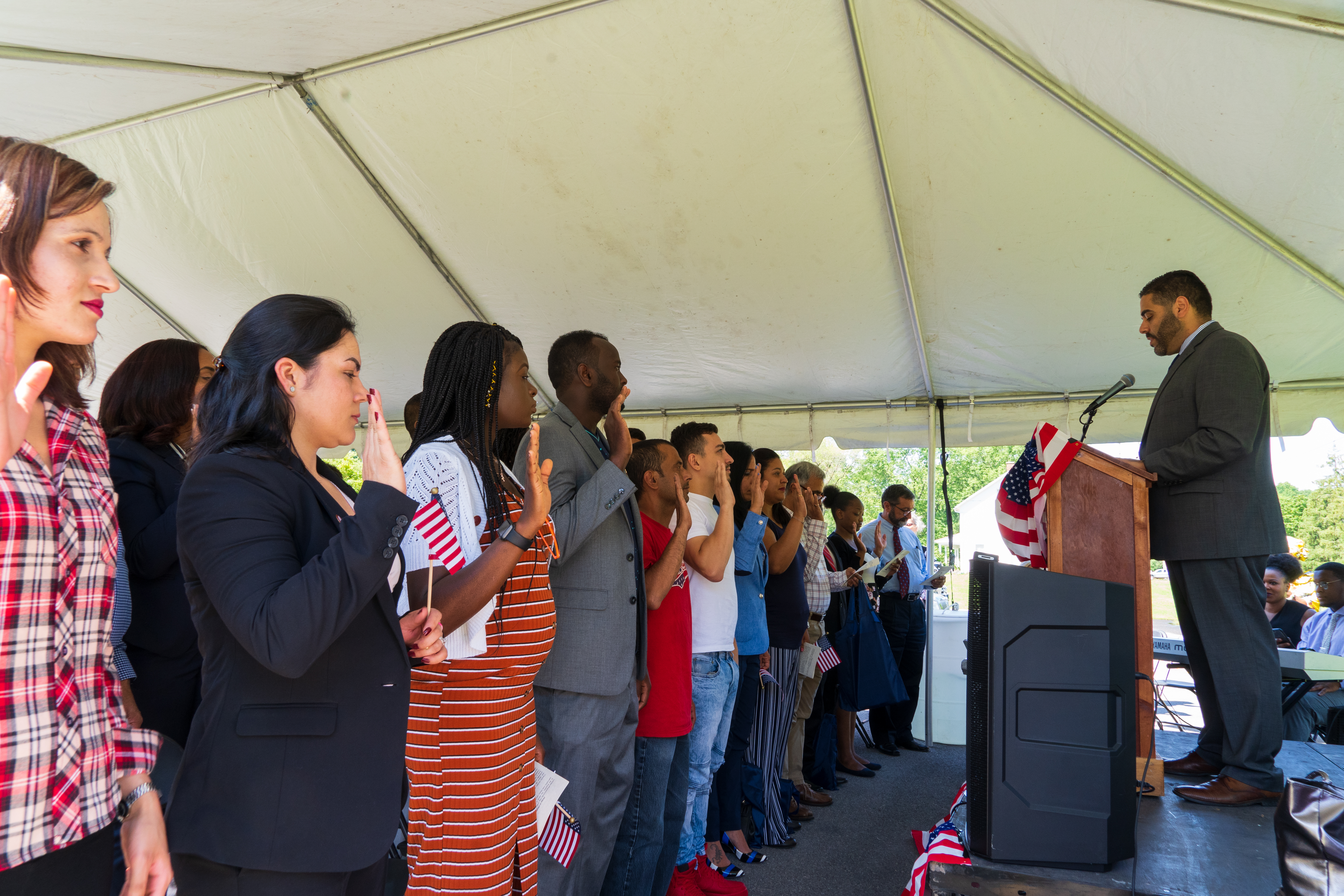 A group of people stand and are sworn in as United States citizens.