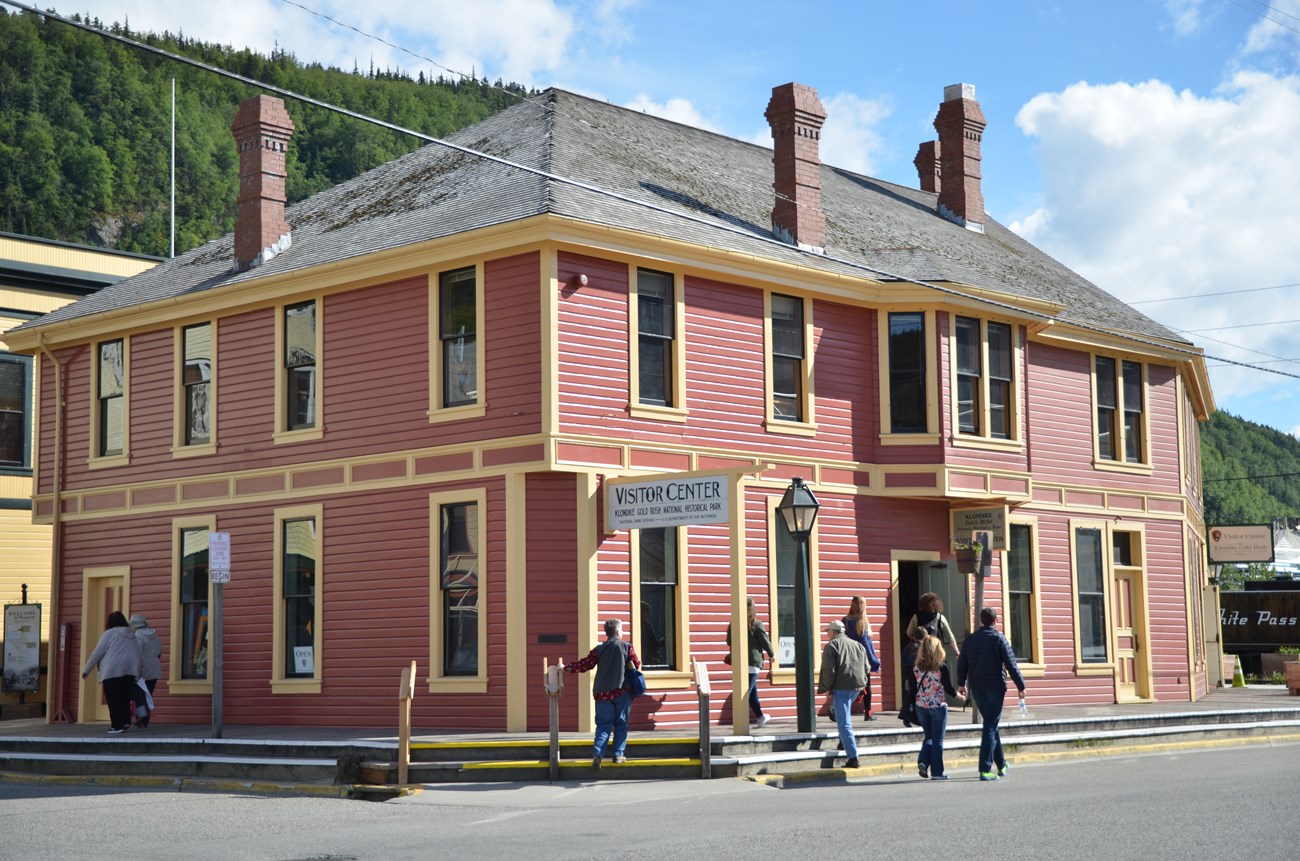 Red building on paved busy street.