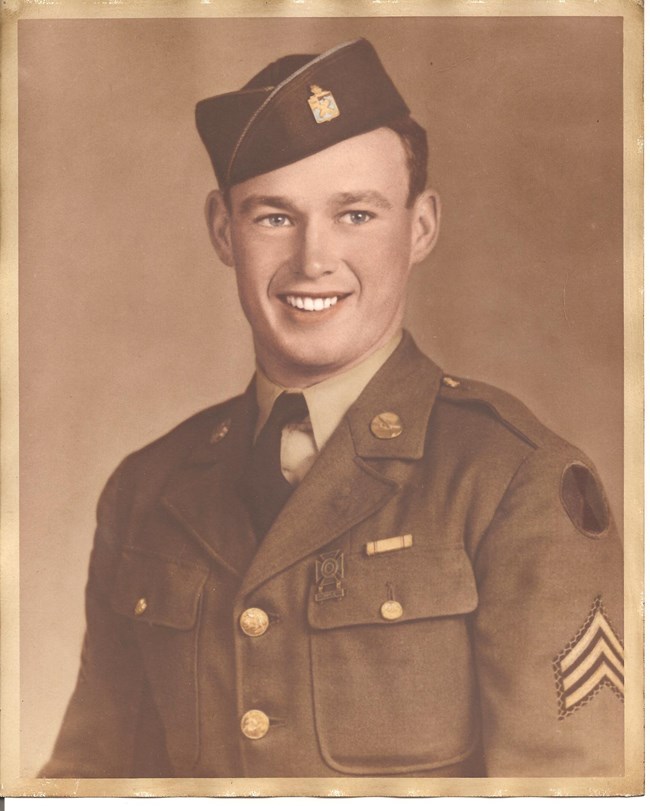 Sephia-toned portrait of smiling man wearing uniform.
